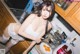 A woman in a white lingerie posing in a kitchen.