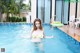 A woman in a bikini standing in a swimming pool.