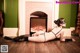 A woman in a black lingerie laying on the floor in front of a fireplace.