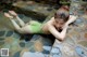 A woman in a green bathing suit laying on the ground.