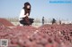 A woman sitting on top of a pile of grapes.