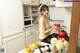 A woman standing in a kitchen holding a cup of coffee.