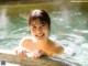 A woman in a hot tub smiling at the camera.