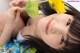 A young girl laying on the floor with a yellow flower in her hair.